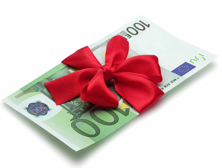 Hundert-Euro-Schein eingewickelt in rotem Geschenkband mit Schleife
